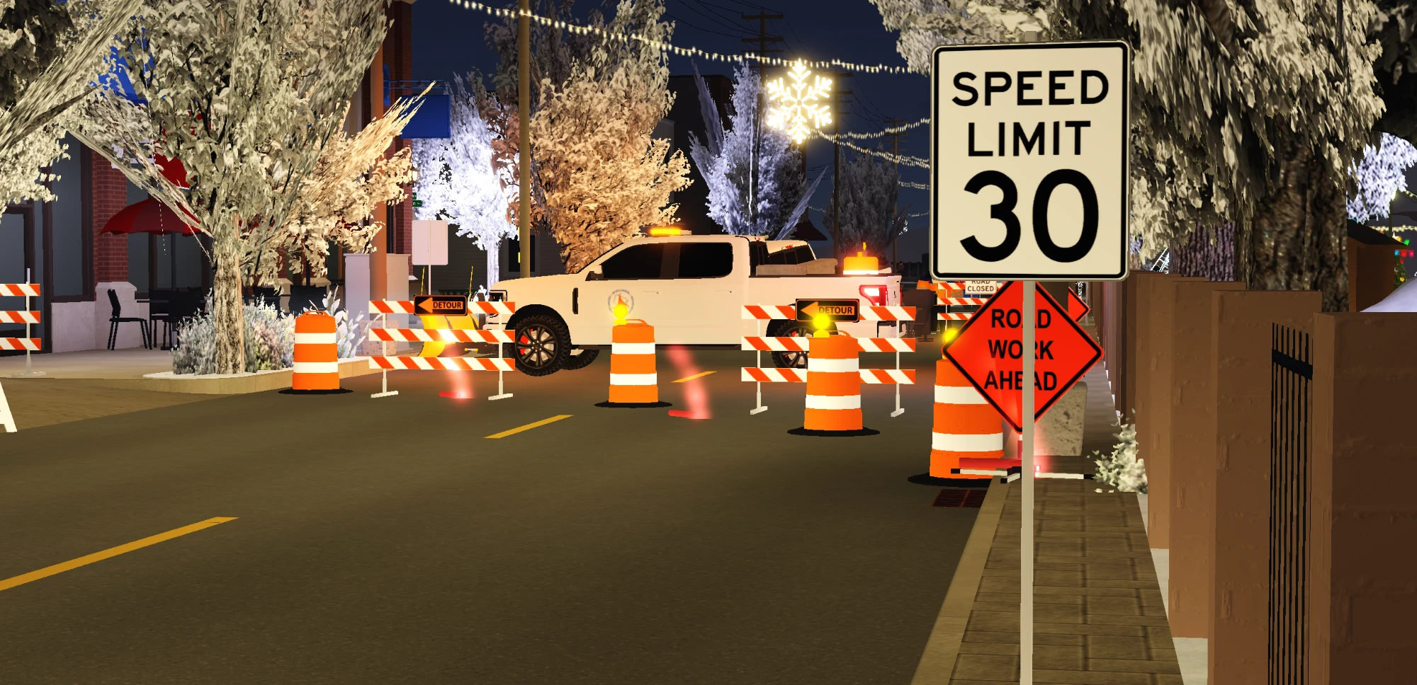 A white WisDOT pickup behind orange barrels, detour signs and a Road Work Ahead sign, at night.
